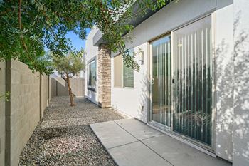 The entrance to a house with a sidewalk and a glass door